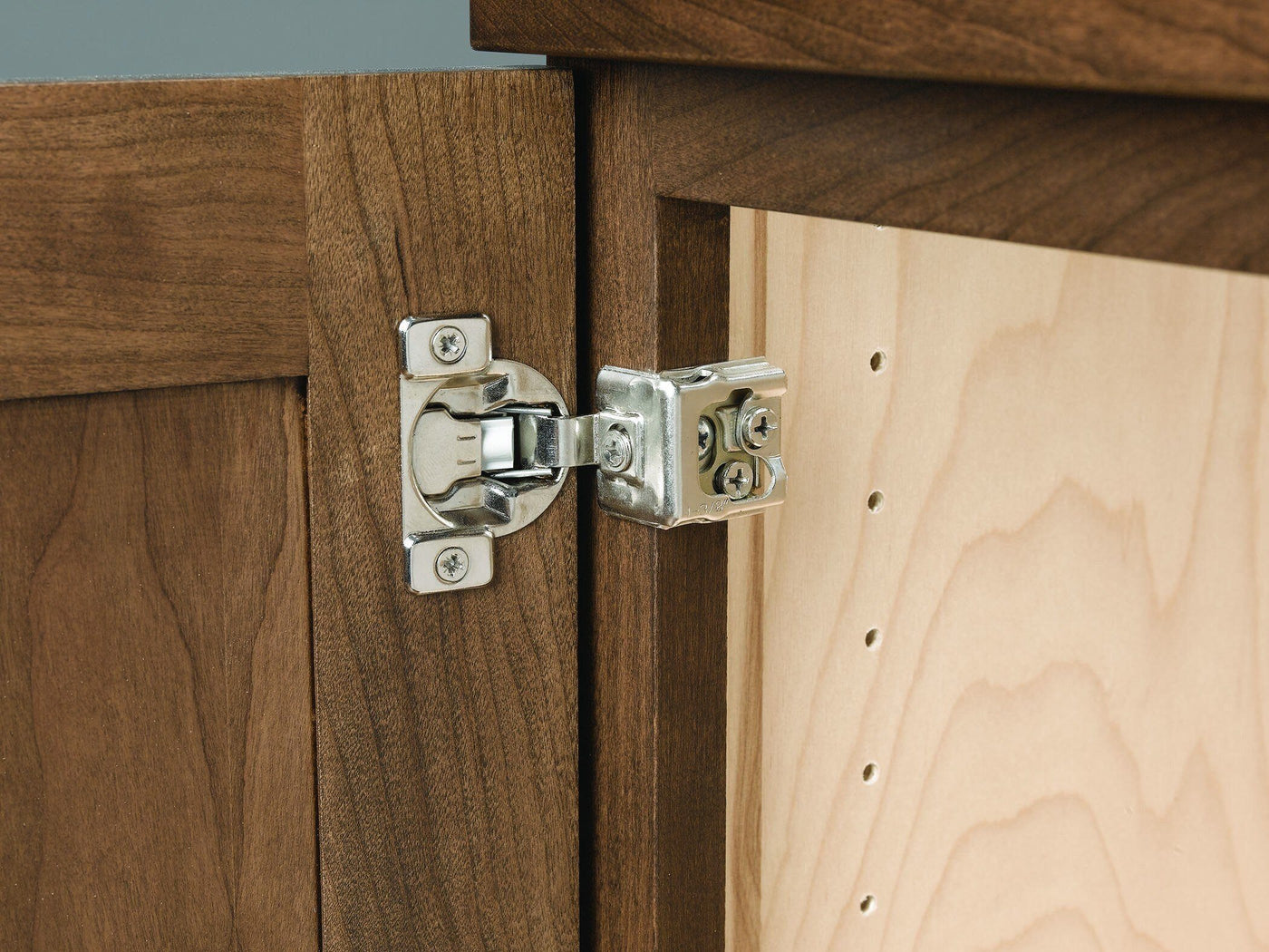Close-up view of European concealed Hinges for Engineered Wood Cabinets installed on a wooden cabinet door